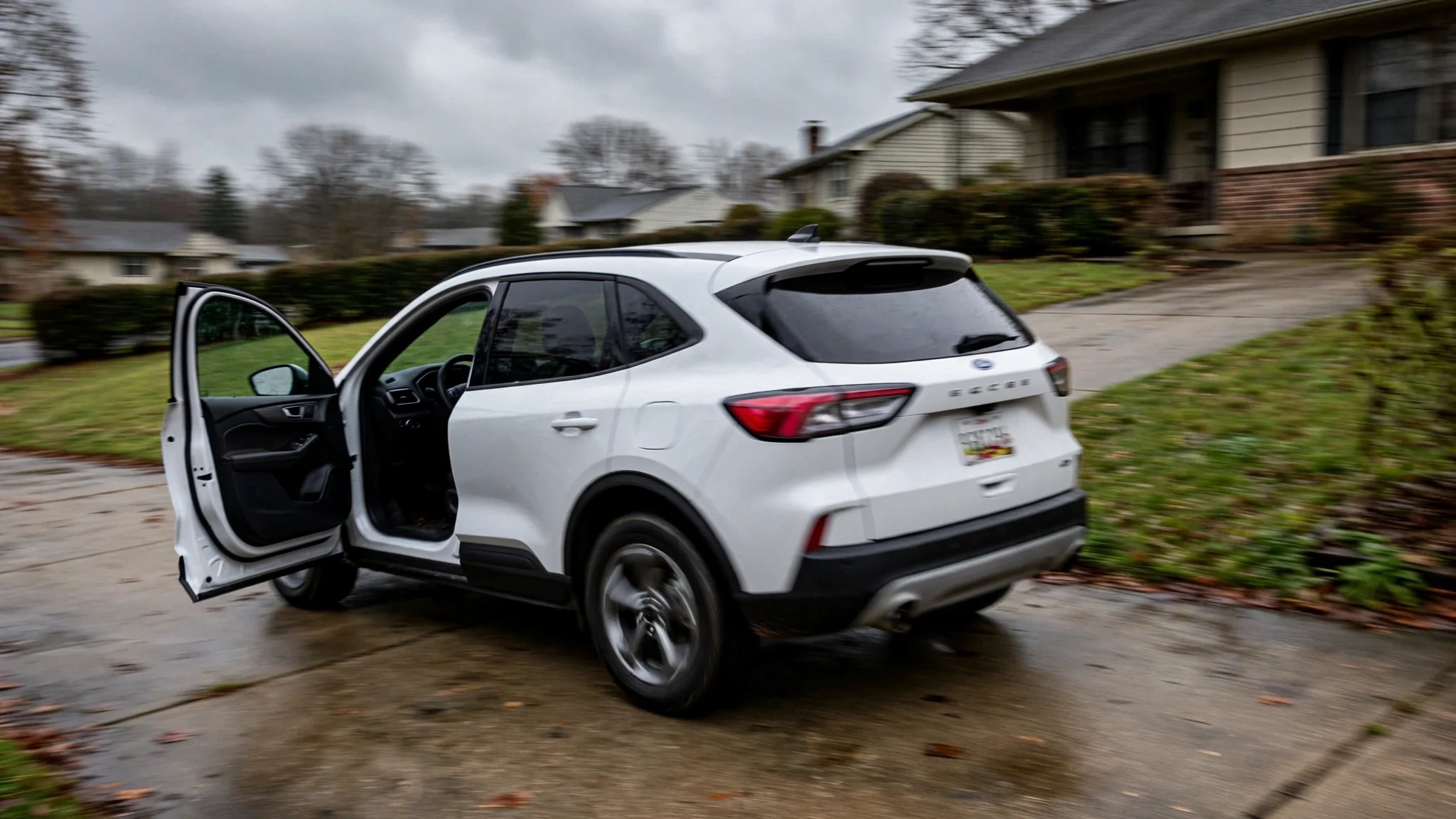 A Ford vehicle rolling backward down a suburban driveway with no driver inside