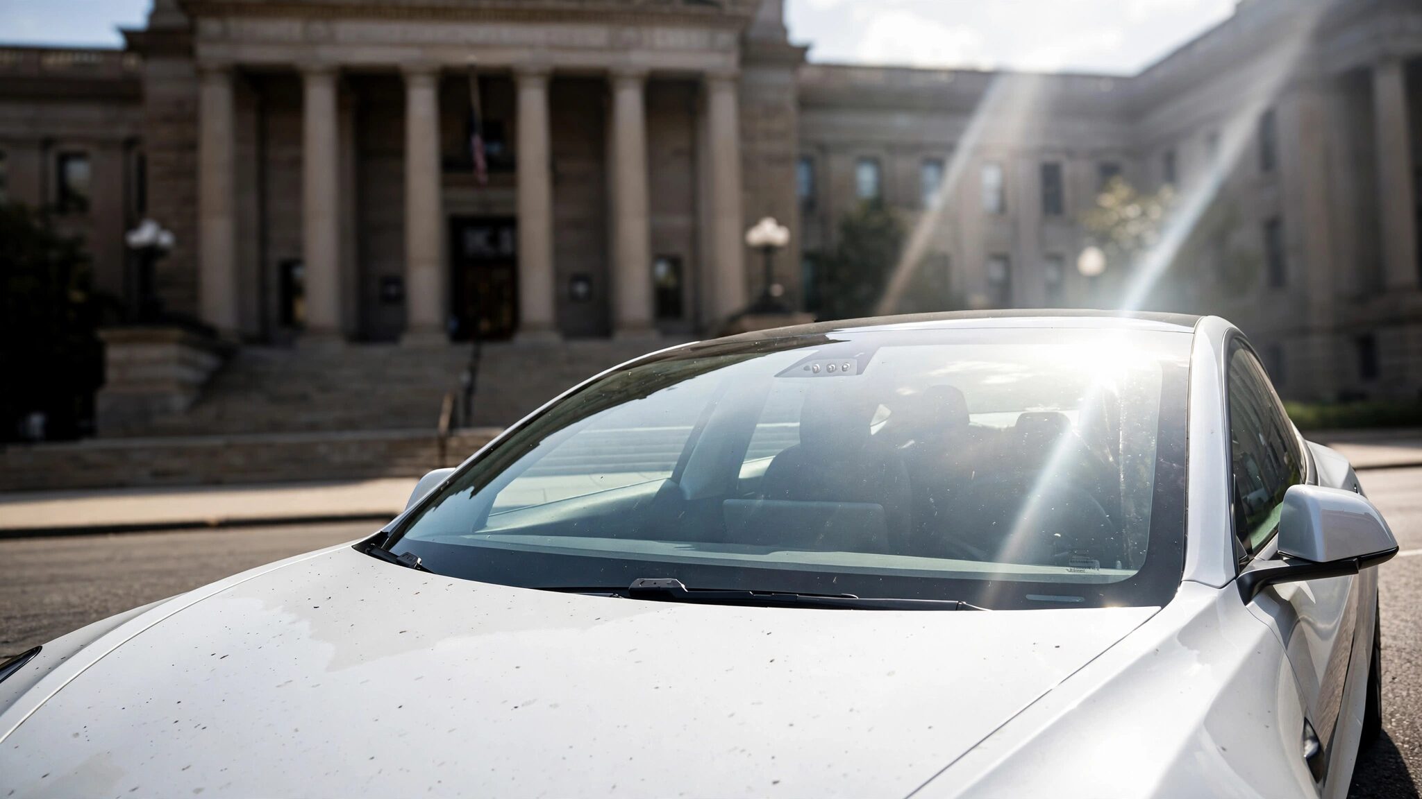 A Tesla Model 3 parked outside a federal courthouse