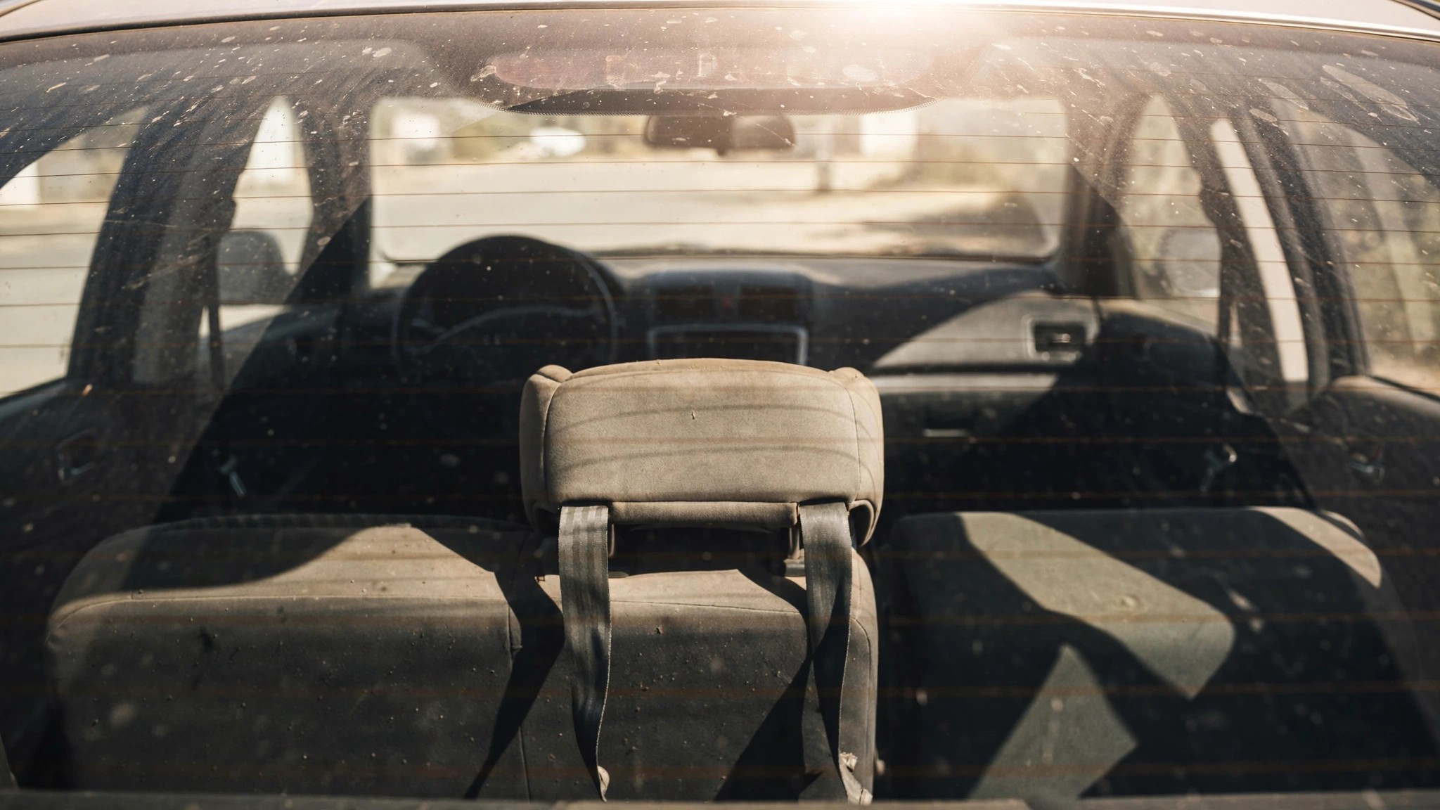 An empty child car seat in a sun-baked vehicle interior
