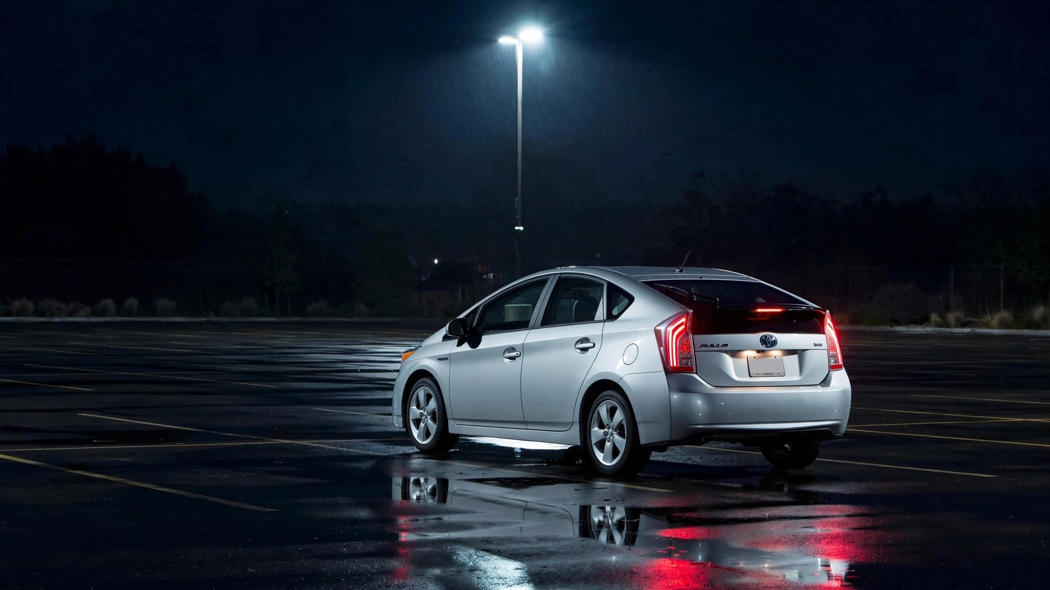 A silver 2010 Toyota Prius under stark lighting in an empty parking lot