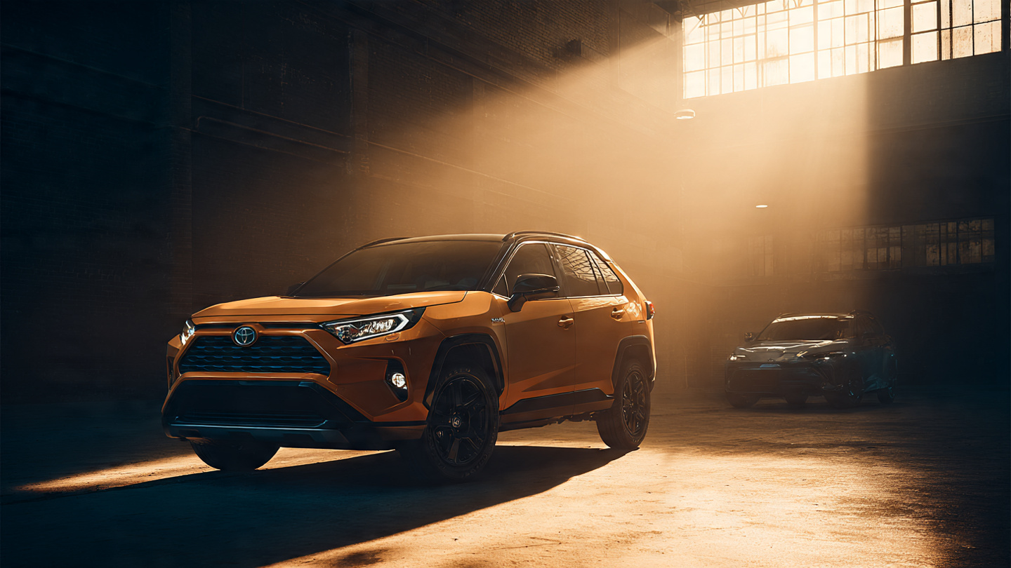 A Toyota RAV4 parked on a suburban street, afternoon sunlight on its profile