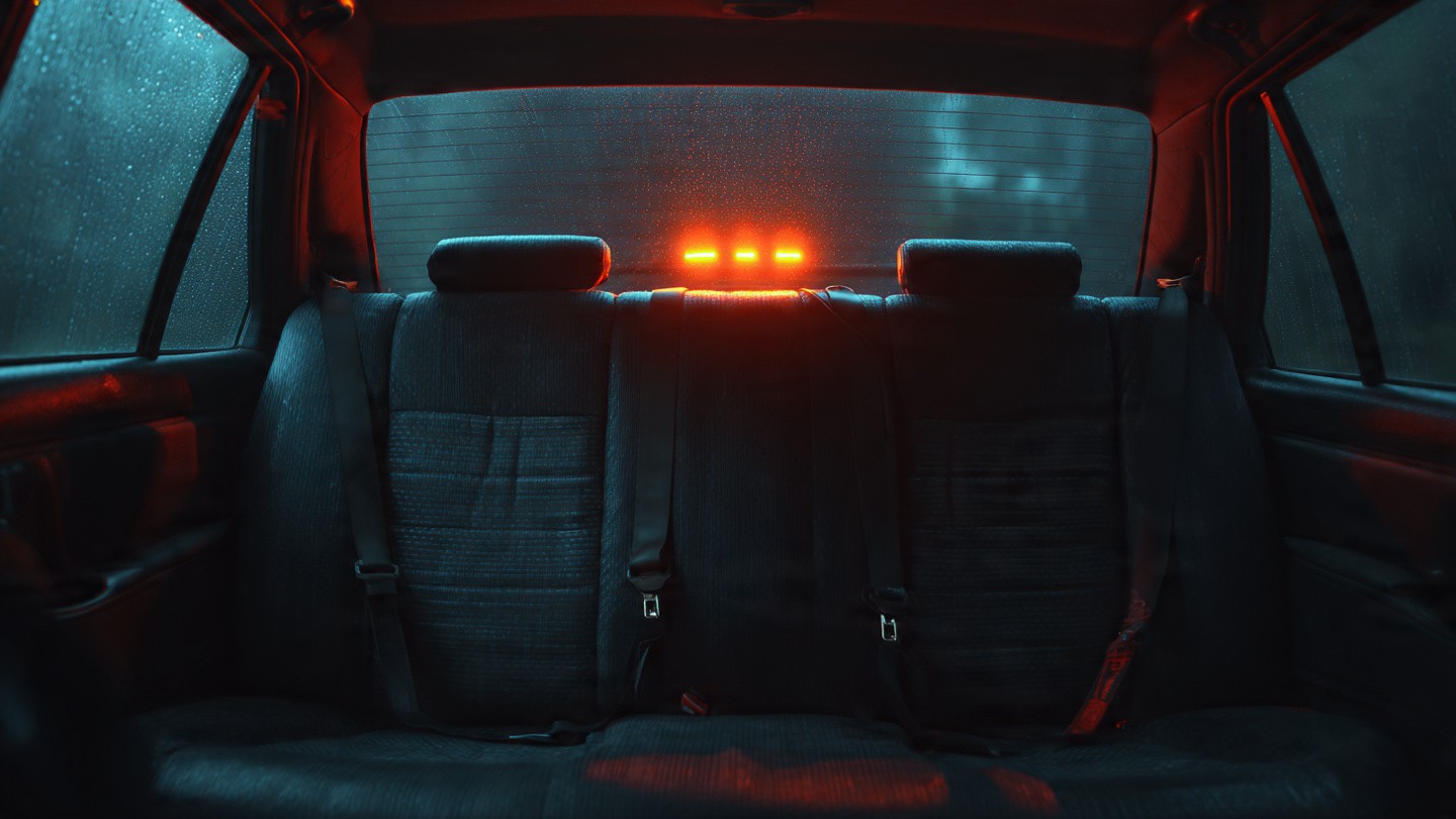 A dimly lit car interior viewed from the back seat showing illuminated seatbelt warning lights on the dashboard, with an empty rear bench and unbuckled seatbelts hanging loose