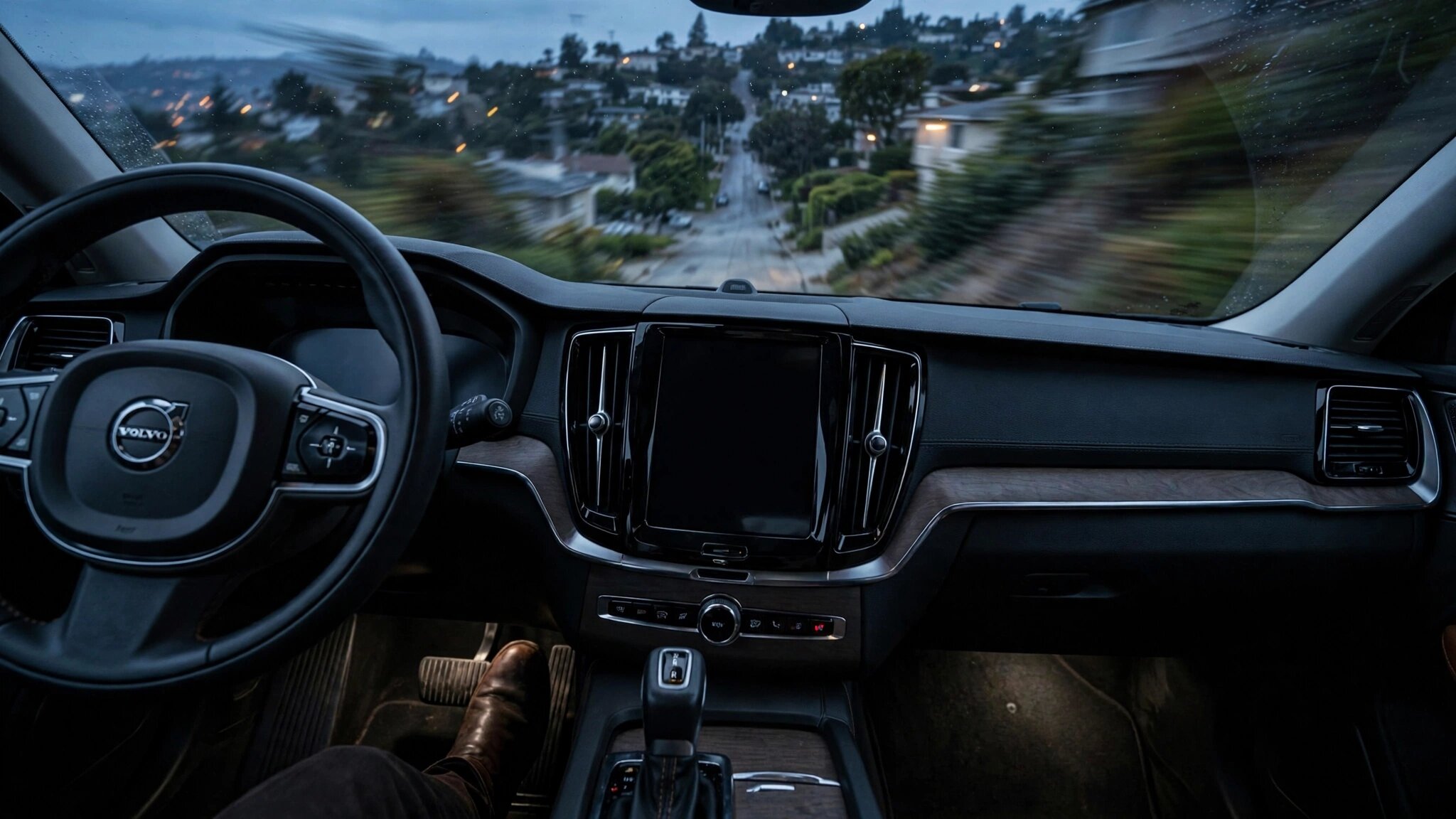 A Volvo XC90 on a hill with brake warning lights illuminated and an OTA update notification on the dashboard screen